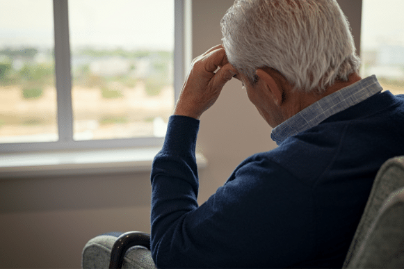 sad older man sitting on a couch