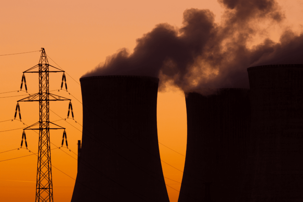 silhouette of two nuclear power plant cooling towers at dusk
