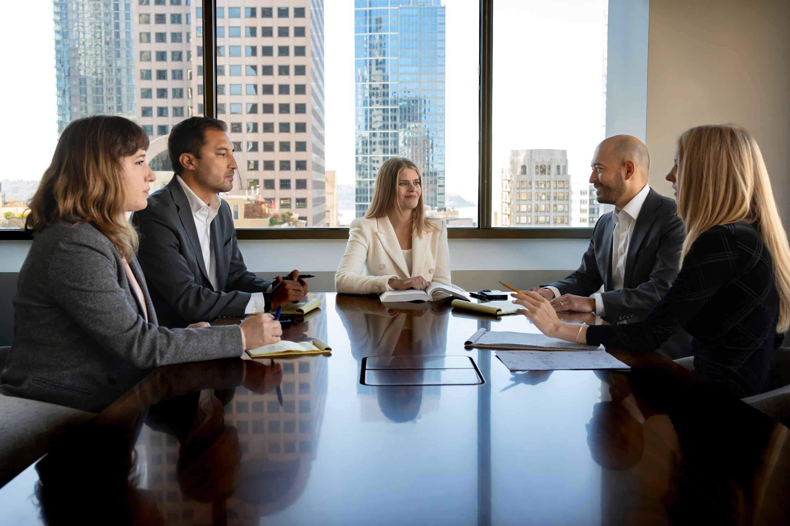 Five asbestos attorneys and partners engaged in discussion around a conference table at Bergman Oslund Udo Little law firm
