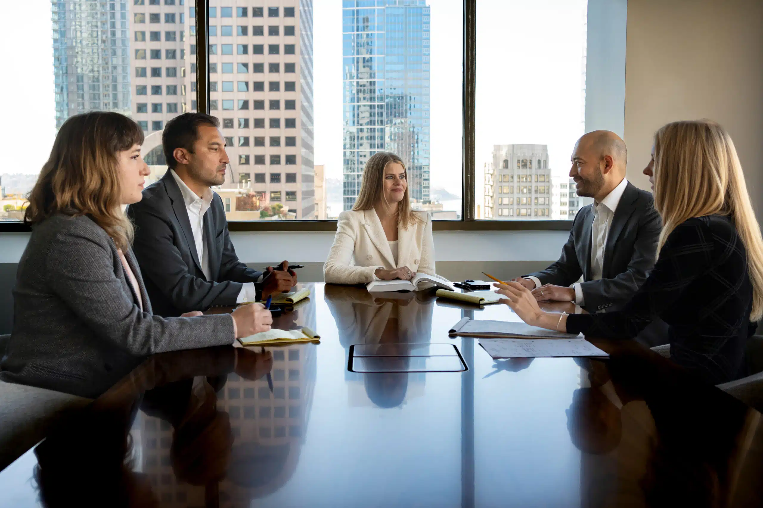 Five asbestos attorneys and partners discuss at a conference table at Bergman Oslund Udo Little.